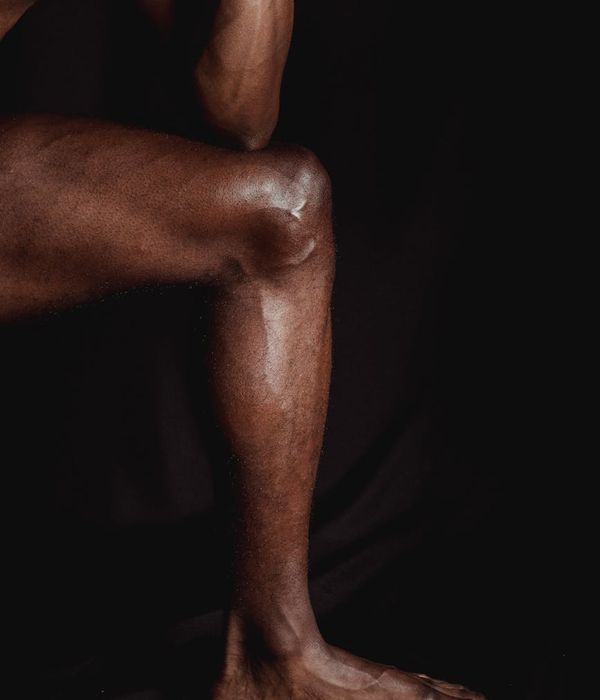Man performing a controlled strength exercise in a minimalist dark gym.